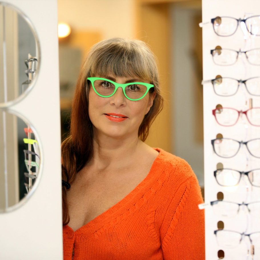 Personal Branding im Optikgeschäft Frau mit grüner Brille bei einer persönlichen Beratung im Optikgeschäft