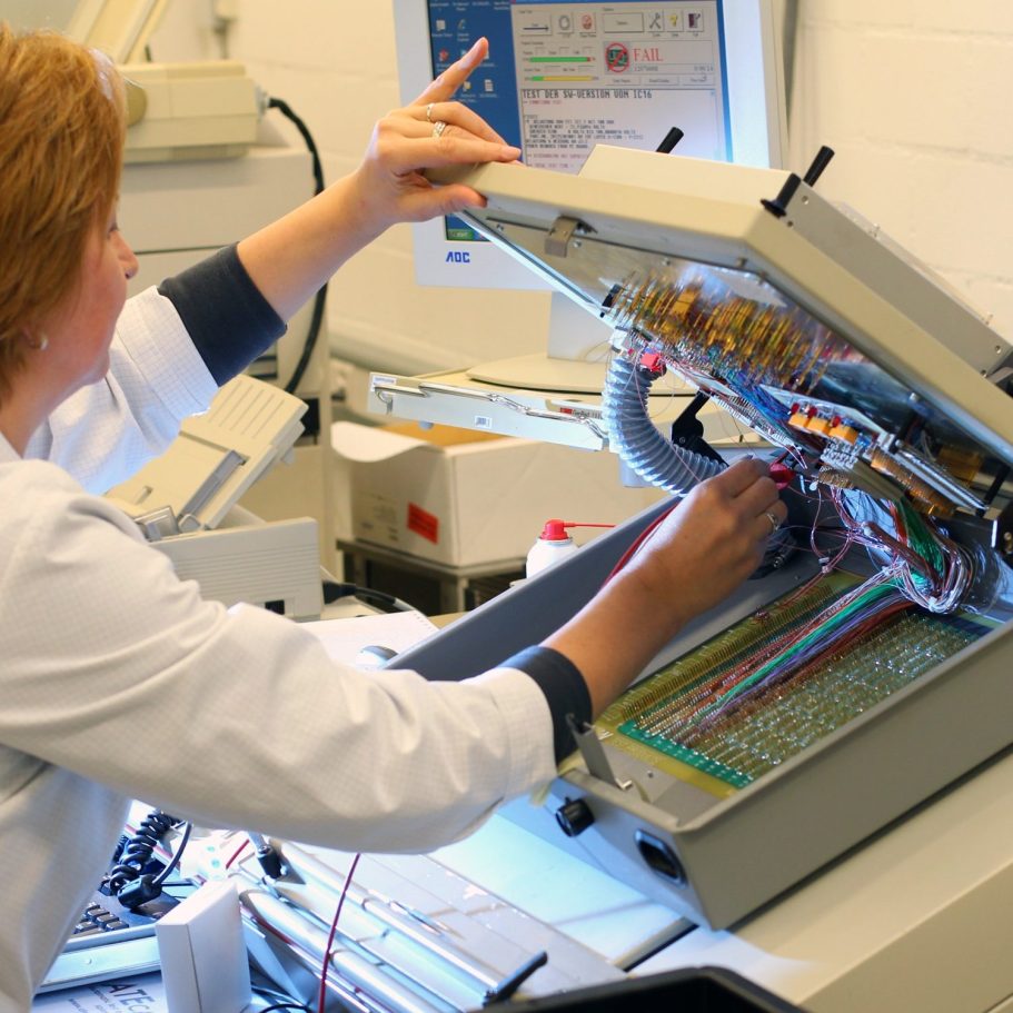 Businessfotografie in der Textilproduktion Mitarbeiterin bedient eine industrielle Stickmaschine in der Textilproduktion